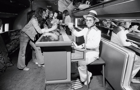English pop star and pianist Elton John travels in a private Boeing jet complete with piano bar during his 1974 US tour. (Photo by Terry O'Neill/Getty Images)